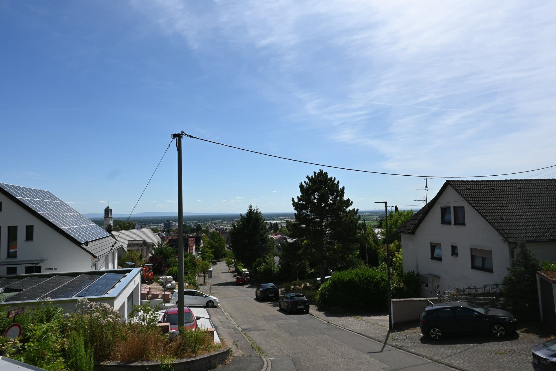 Blick hangabwärts über Neustadt an der Weinstraße und die Rheinebene in der Ferne