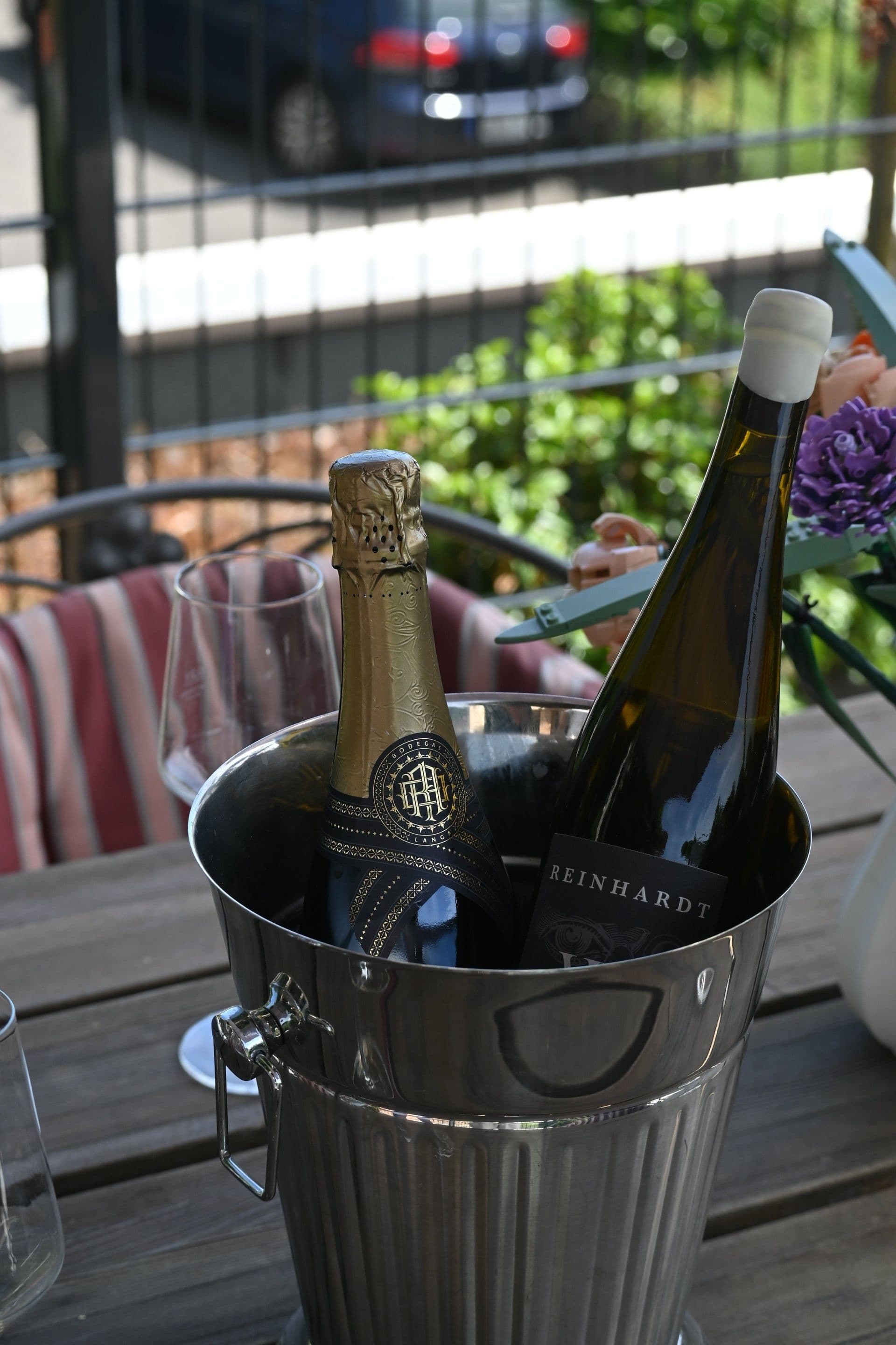 Weingläser und Flasche auf der Terrasse der Ferienwohnung mit Blick über die Rheinebene